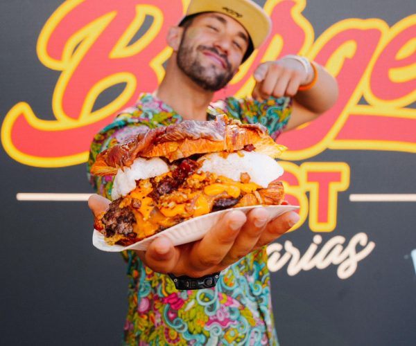 Iván Villarij mostrando una hamburguesa gourmet durante un evento gastronómico
